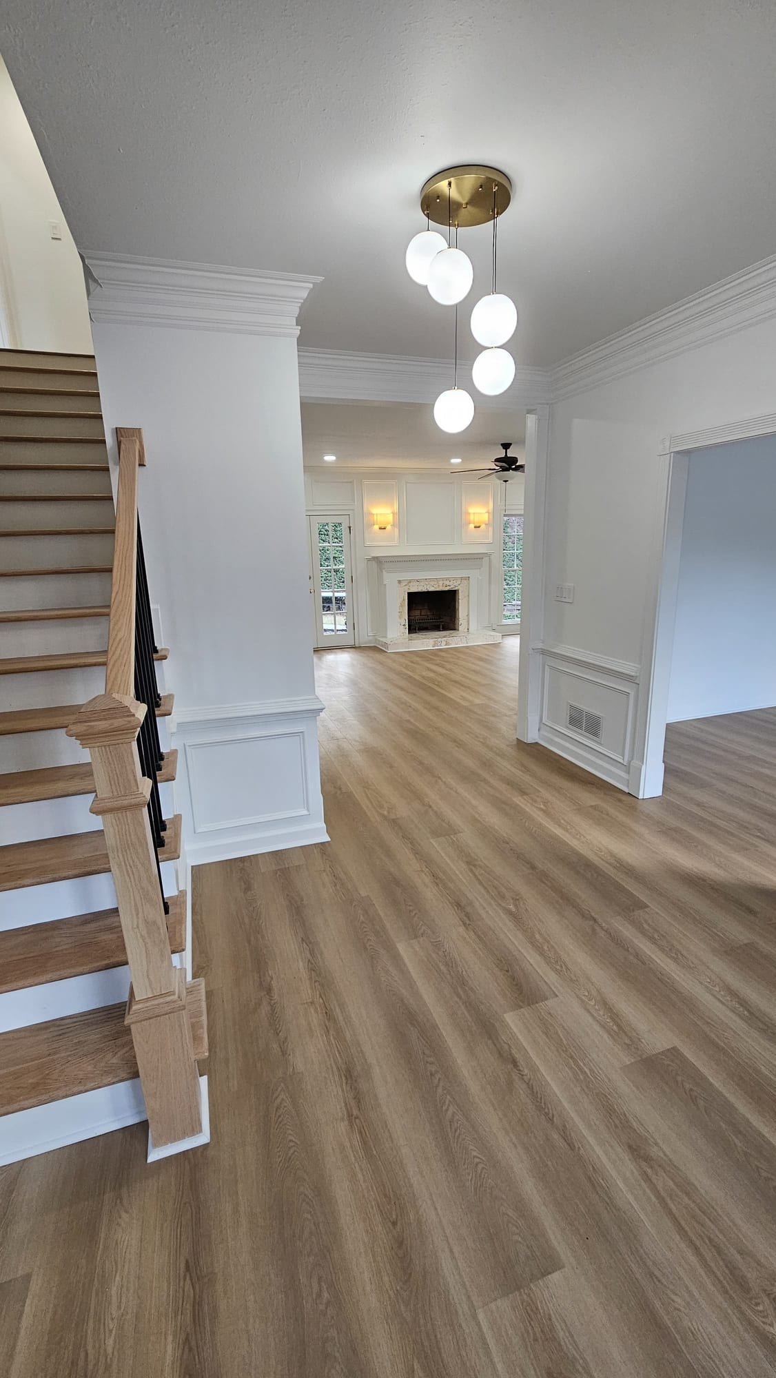 Bedroom with a ceiling fan, two double-hung windows, and wainscoting