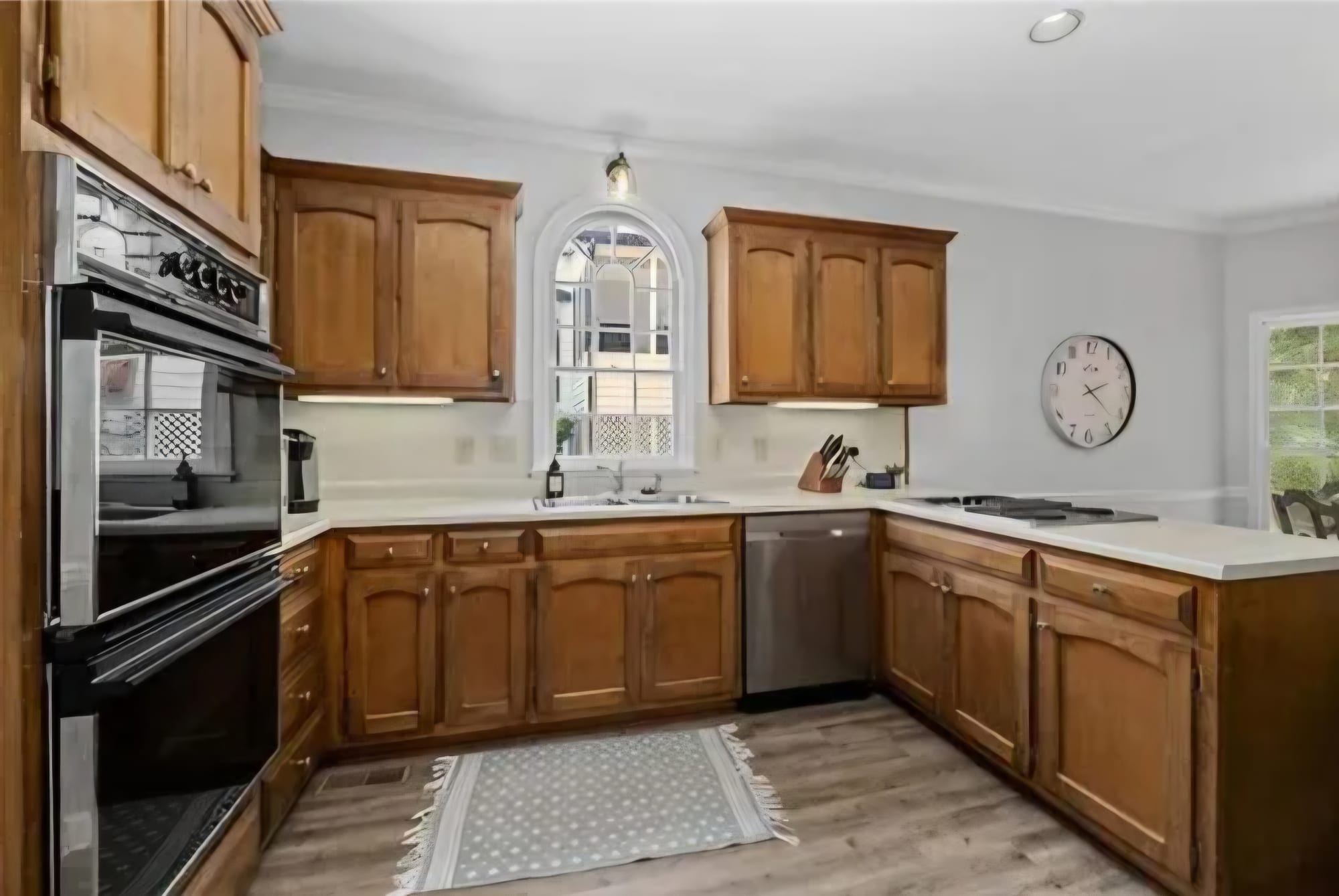 Kitchen with oak cabinets and a cooktop, before renovation