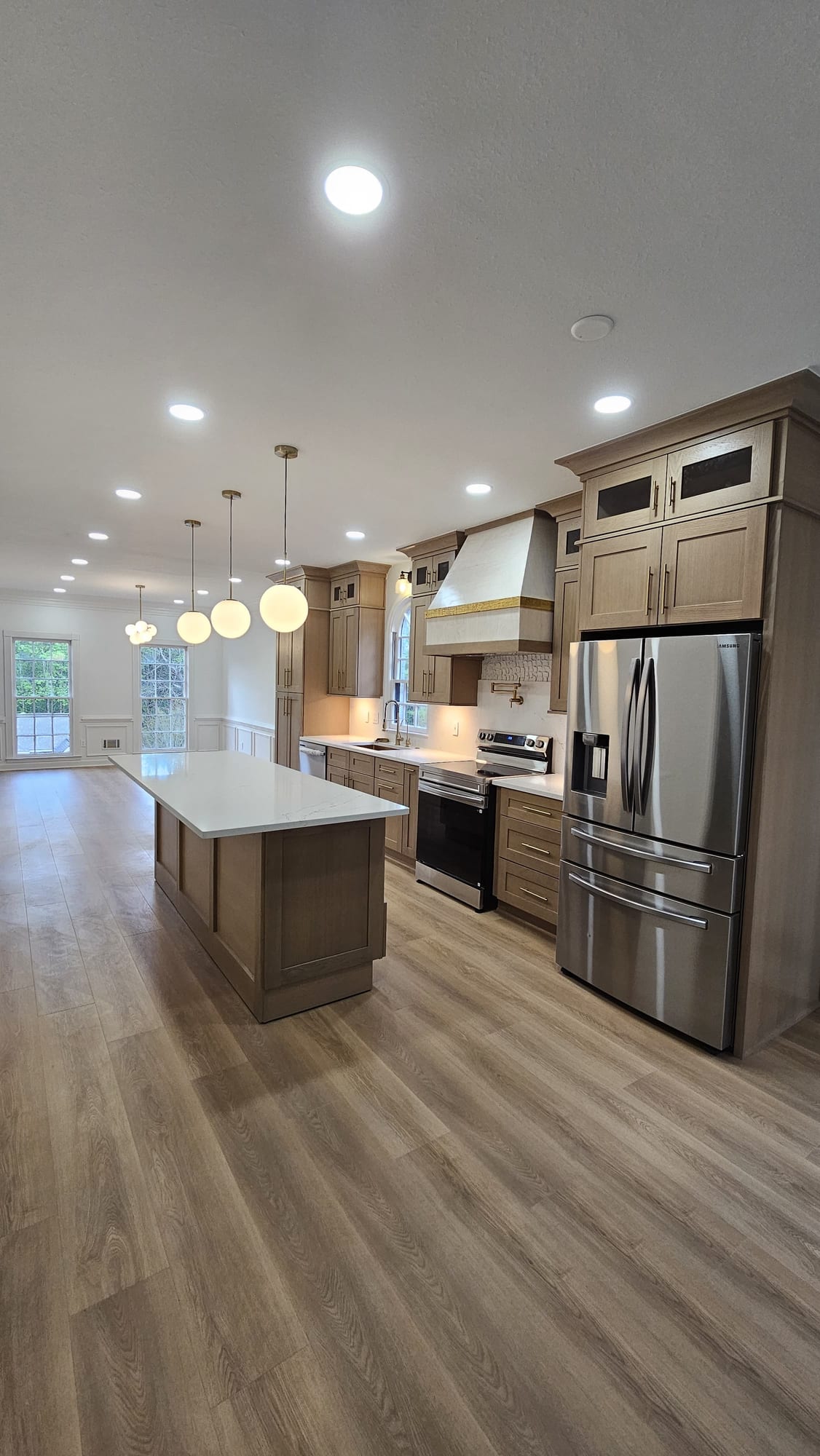 Renovated kitchen with wood cabinetry, an island, and a stainless panel refrigerator