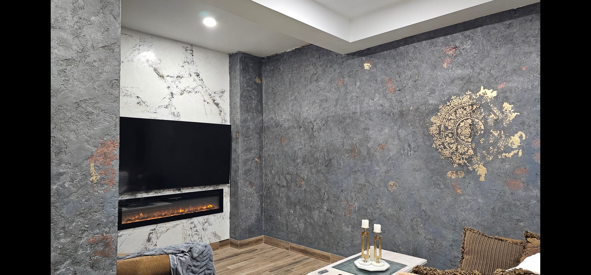Living room with a gray textured plaster accent wall and a built-in fireplace