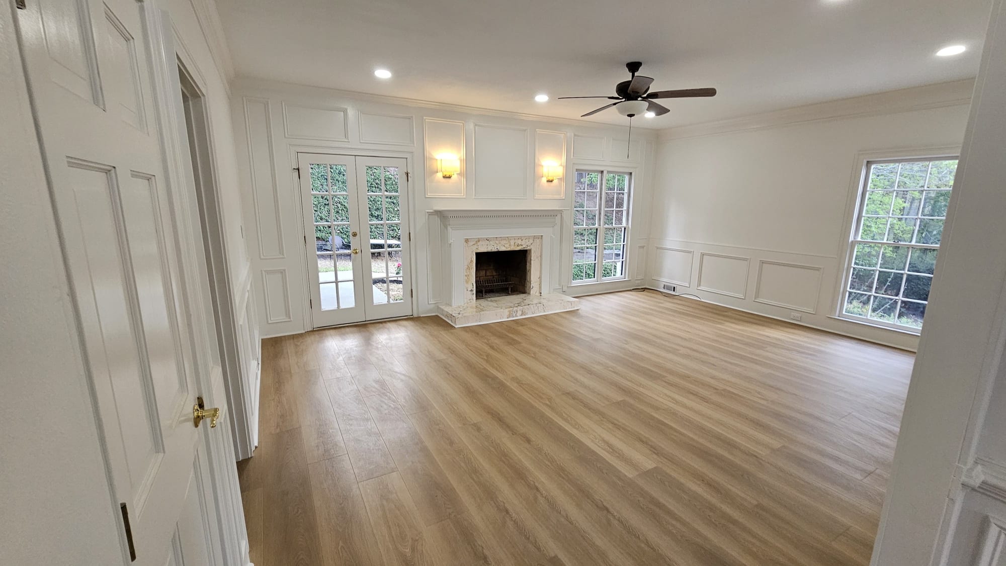 Living room with a white fireplace mantel and brass door hardware