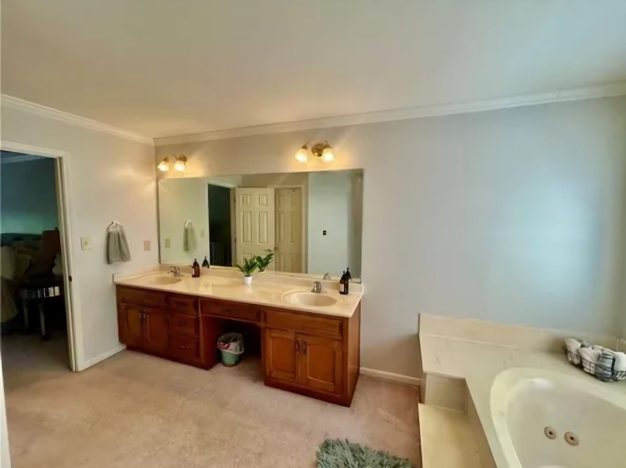 Primary bathroom with a cherry wood double vanity and garden tub, before renovation
